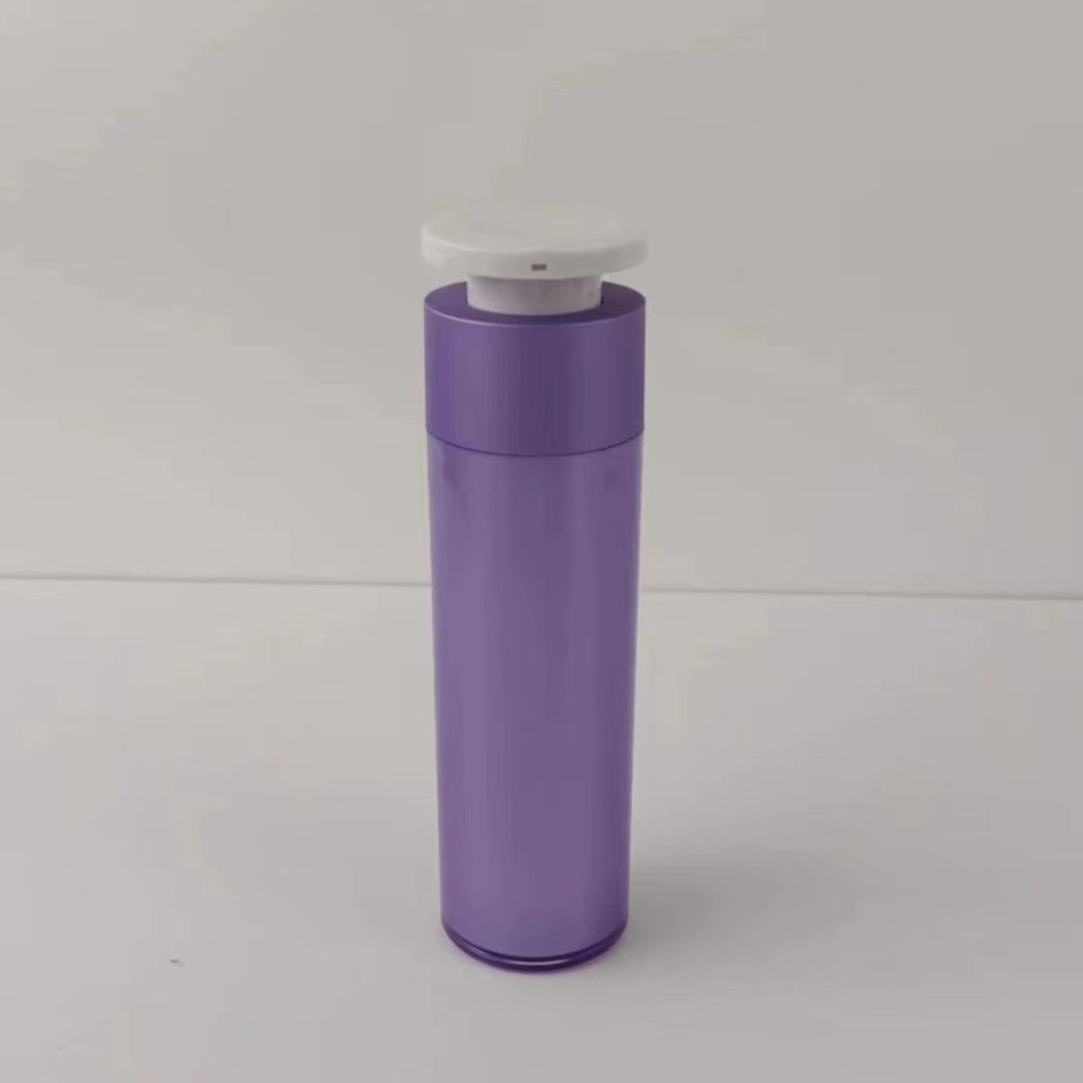 Bouteille pour distributeur cosmétique en plastique violet avec pompe à pression blanche